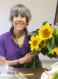 Volunteer Laurie holding sunflowers